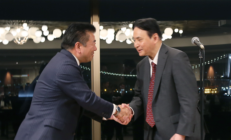 握手をする重村氏と殷